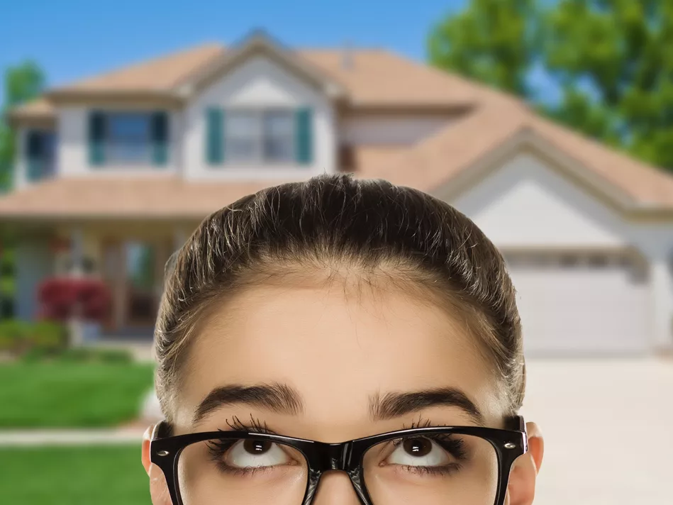 A girl in glasses looks back toward her house wondering; is a home warranty worth it?
